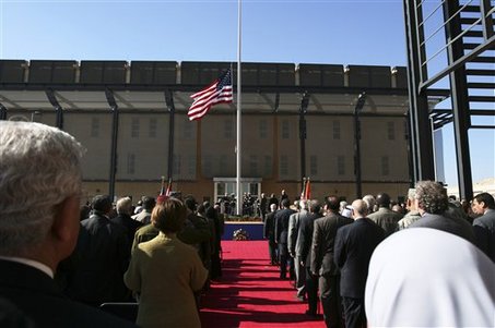 People watch the U.S. flag as it is raised during a ceremony marking the opening of the new U.S. Embassy in Baghdad, Iraq, Monday, Jan. 5, 2009. The embassy in Baghdad is one of the largest U.S. embassies in the world.  (AP Photo/Hadi Mizban)
