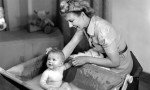 Woman bathing a baby 1948