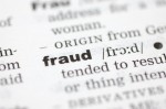 A close up of the word fraud from a dictionary