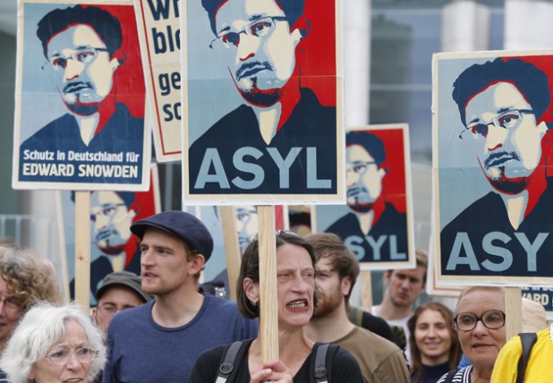 Demonstrators hold banner during protest rally in support of Snowden in Berlin
